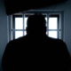 silhouette of a man in window mediano
